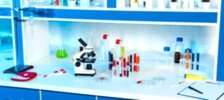 flasks, test tubes and bottles near microscope in modern laboratory